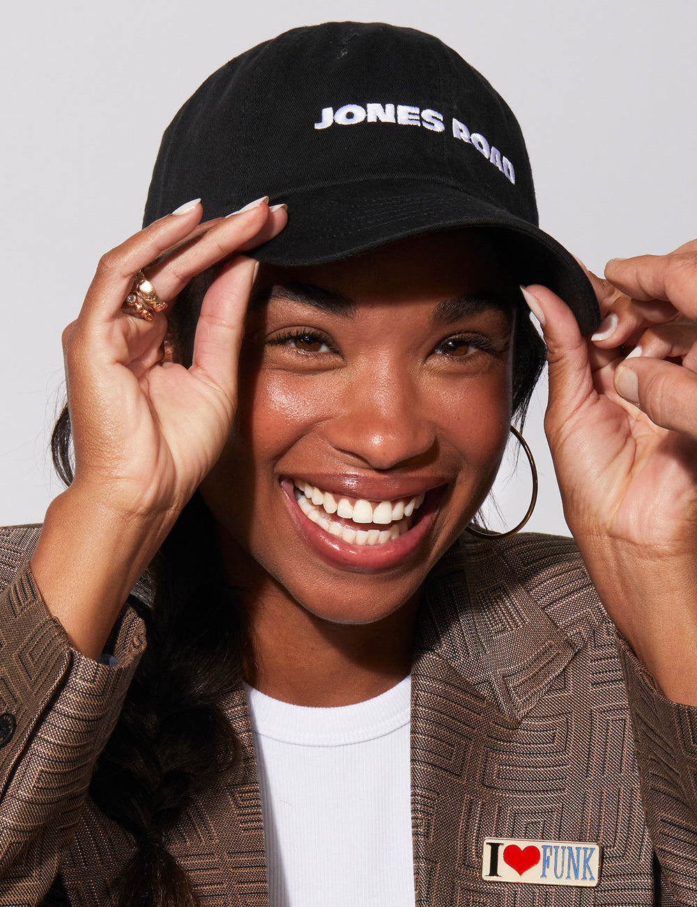 A woman wearing The Hat by Jones Road Beauty
