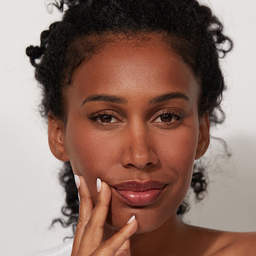 A woman wearing Jones Road Beauty's Lip Tint in Nude Rose for a "no makeup" makeup look